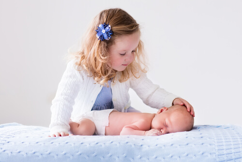 girl-holding-her-newborn-brother
